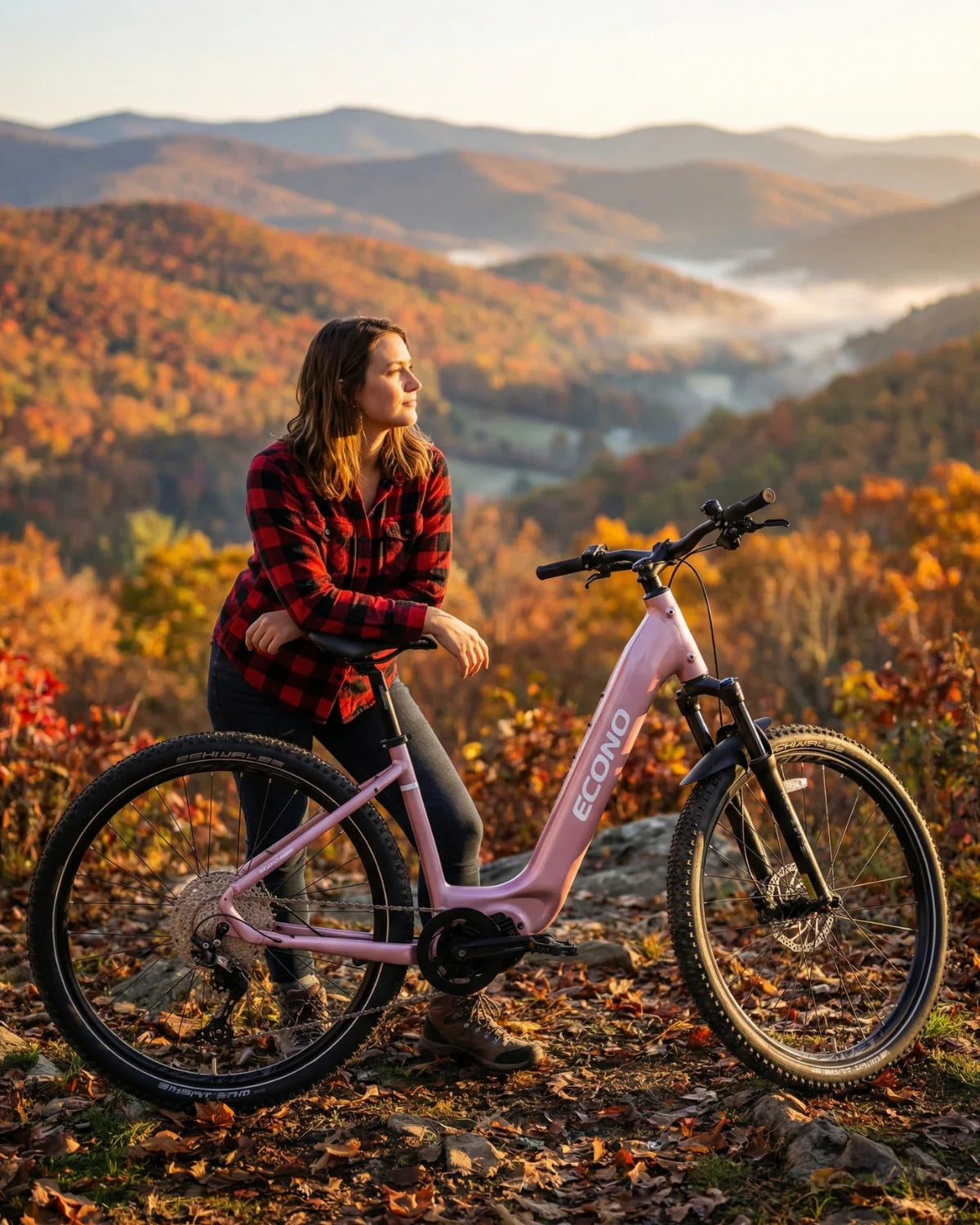 Žena uz ružičasti električni bicikl Econo Gams MTB 29 u jesenskom krajoliku, bočni prikaz