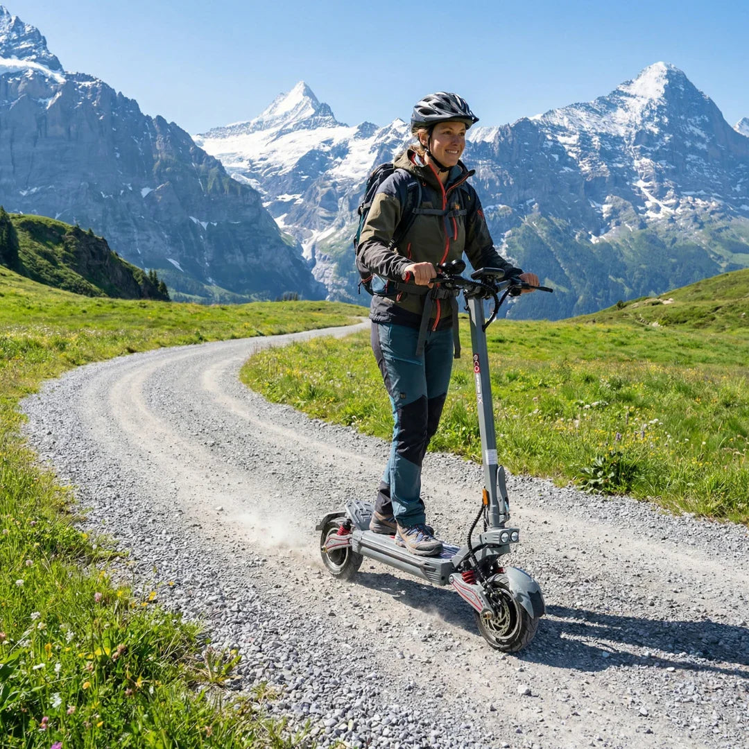 Žena vozi sivi električni romobil Eco Speed 10x v2 po makadamskom putu u planinama