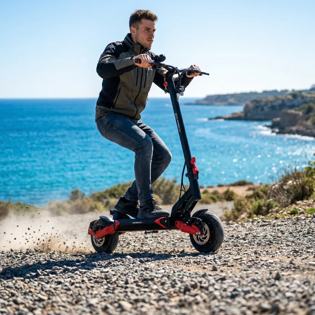 Muškarac vozi električni romobil Teverun Eco Speed 9X po šljunčanom terenu uz more