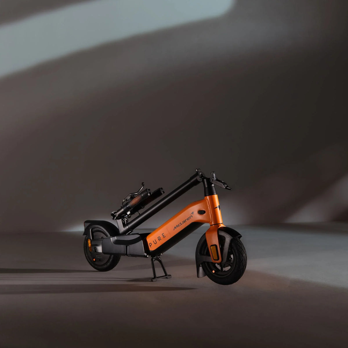 Sklopljeni električni romobil Pure Advance McLaren Edition u narančastoj boji, bočni prikaz na