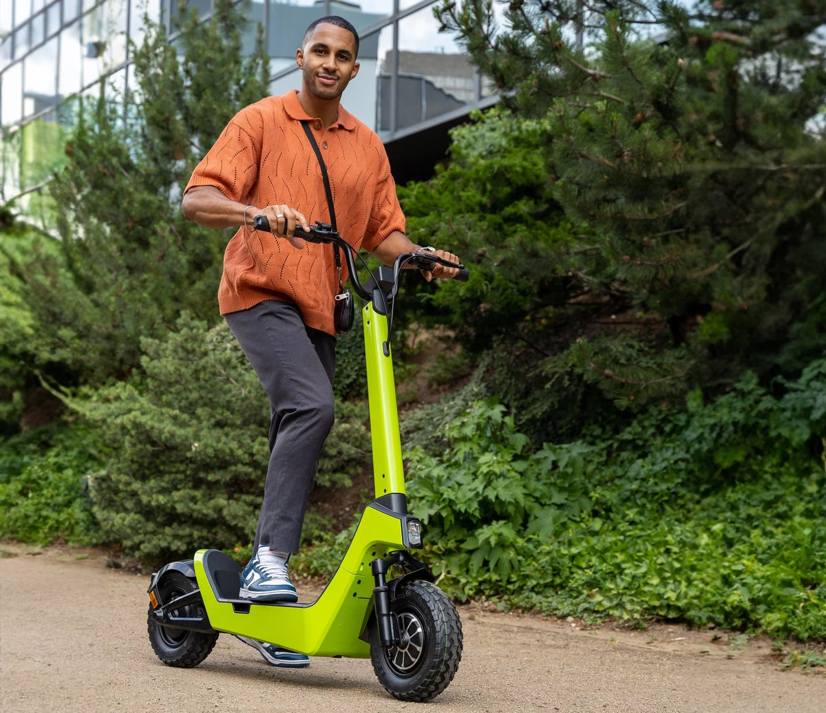 Muškarac vozi zeleni električni romobil Streetbooster Castor na stazi u prirodi