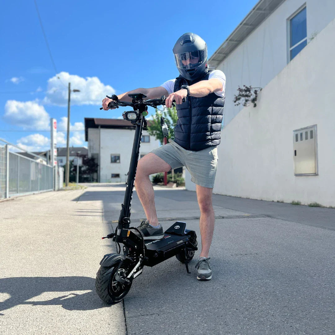 Muškarac s kacigom vozi crni električni romobil Teverun Fighter Supreme 7260 Ultra na otvorenom