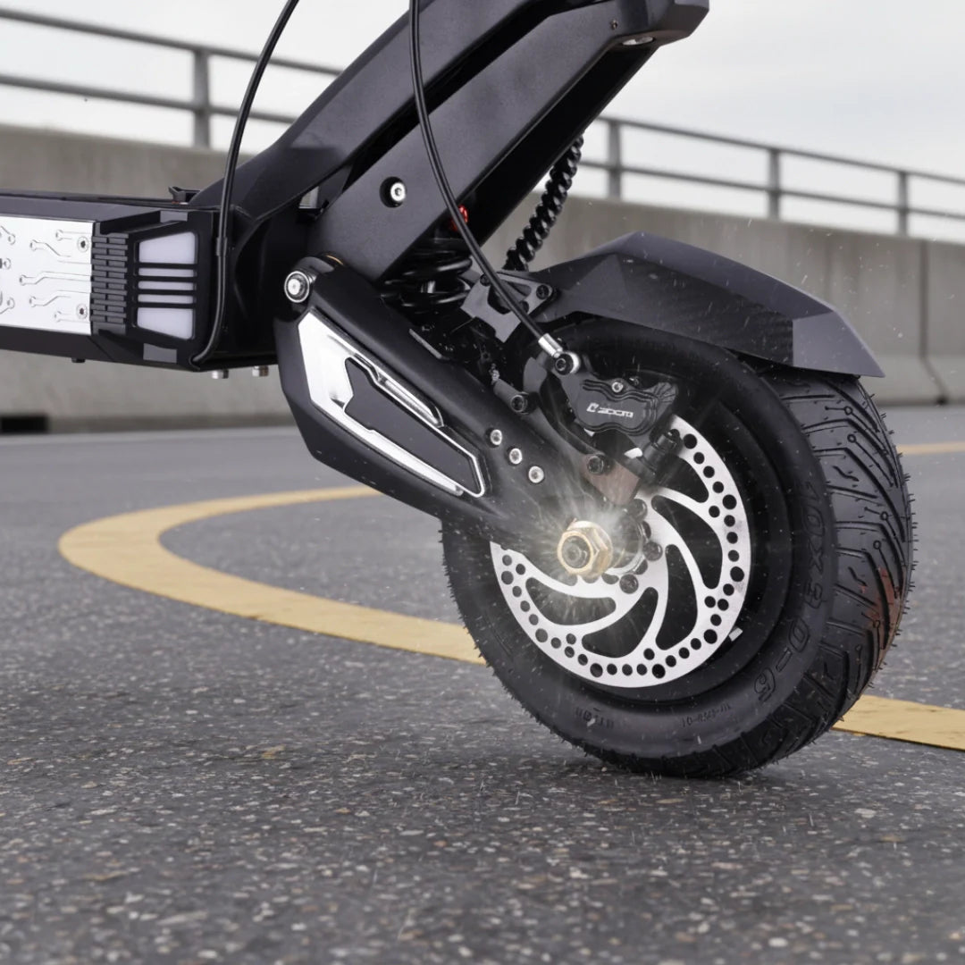 Detalj crnog kotača i disk kočnice električnog romobila Vsett 10 Apex na asfaltu