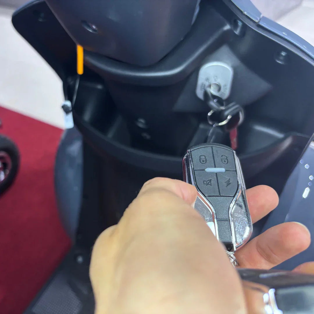 Daljinski ključ za električni skuter Vigorous Vista Q1 u ruci ispred brave vozila