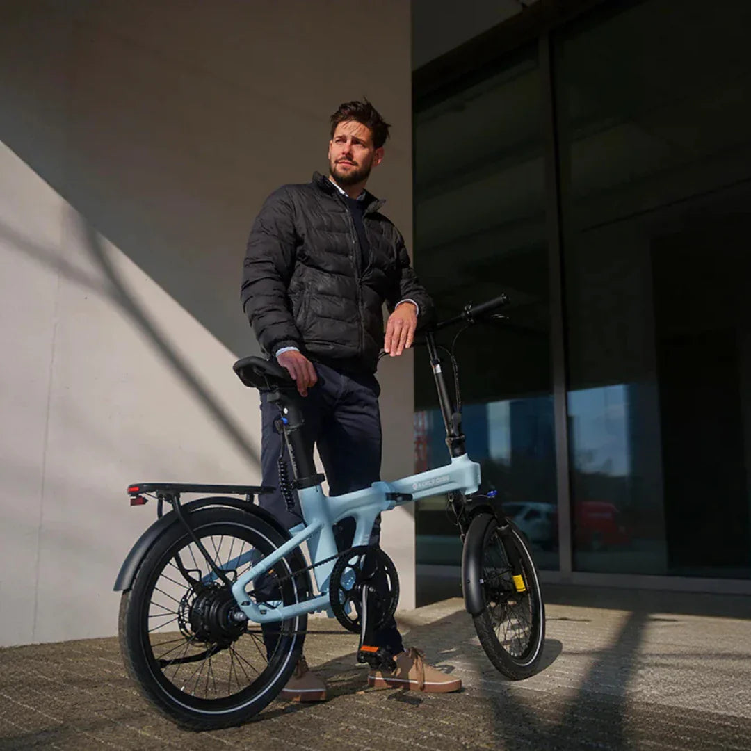 Svijetloplavi sklopivi električni bicikl ADO Air 20 Ultra i vozač u bočnom pogledu