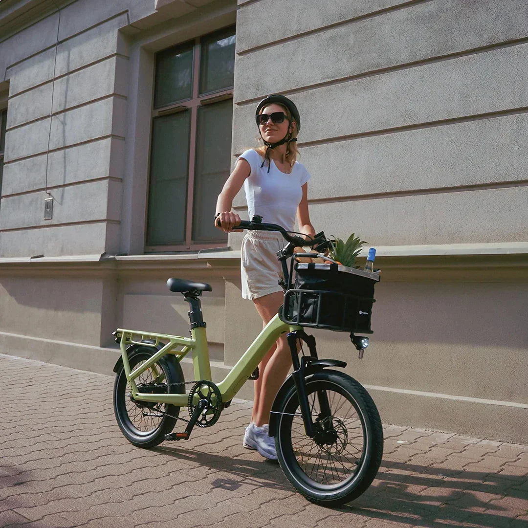 Žena gura limeta zeleni električni bicikl ADO Air 20 Pro s košarom na prednjoj strani