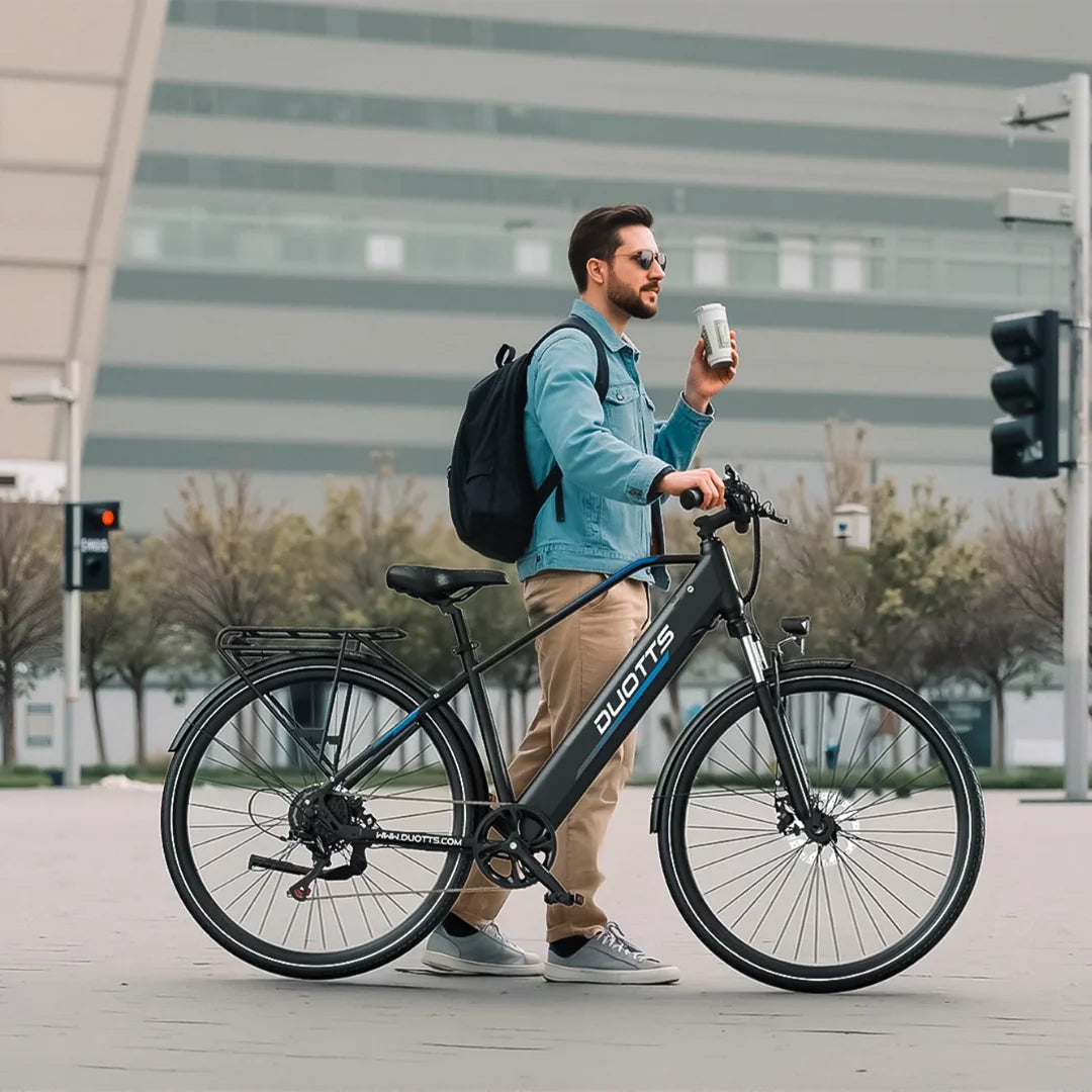 Muškarac s ruksakom pokraj crnog električnog bicikla Duotts C29 Max u urbanoj sredini
