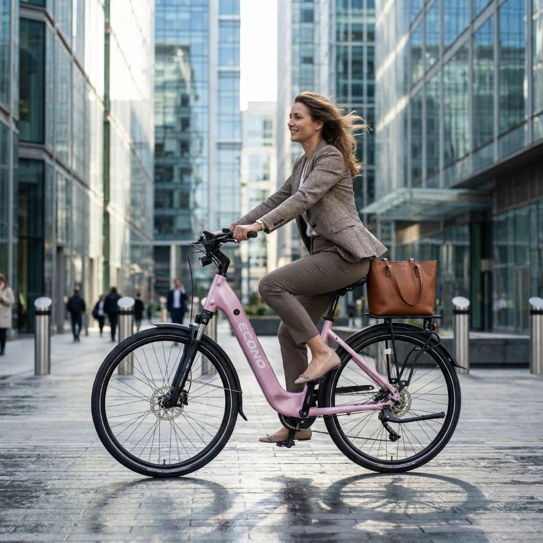 Poslovna žena vozi ružičasti električni bicikl Econo Apes City EER3 2026 u gradskom okruženju