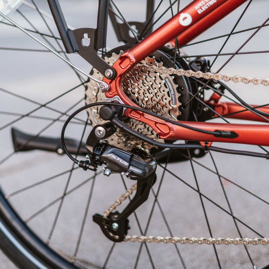 Detaljan prikaz Shimano Altus mjenjača i stražnjeg kotača na crvenom električnom biciklu Econo Apes
