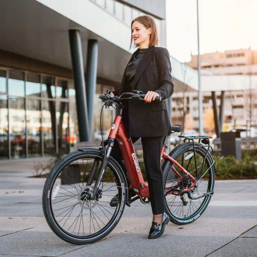 Poslovna žena na crvenom električnom biciklu Econo Apes EER4 ispred moderne zgrade