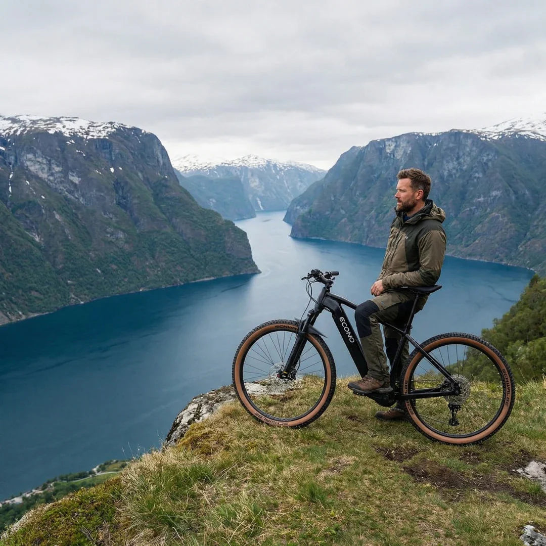 Crni električni bicikl Econo Gams MTB 29 C6 2026 s vozačem na litici iznad fjordova