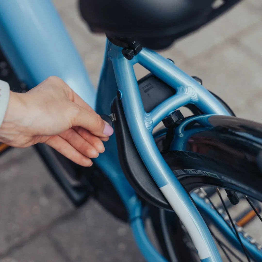 Ruka otključava bateriju na plavom električnom biciklu Econo Mare City EECALK-AUTO