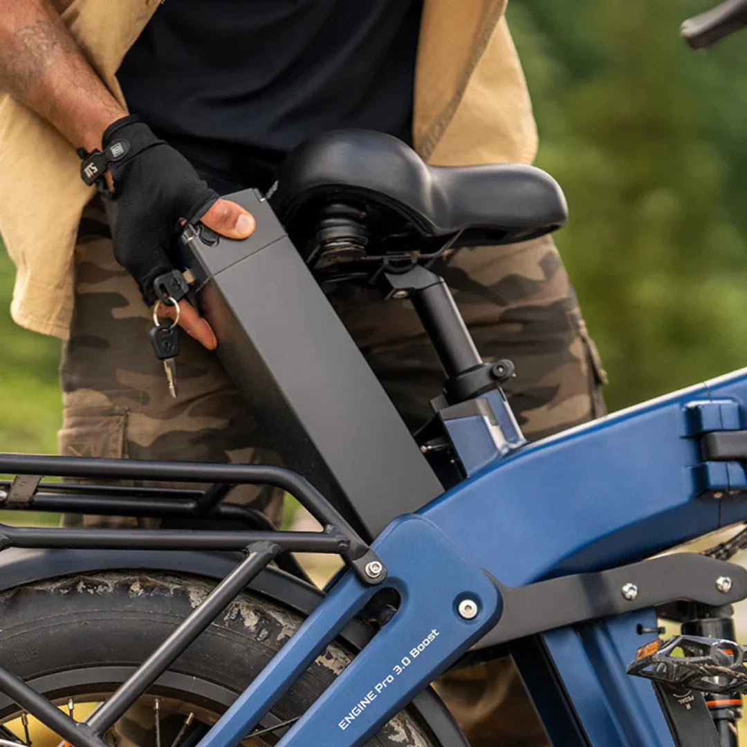Osoba vadi bateriju iz plavog električnog bicikla Engwe Engine Pro 3.0 Boost