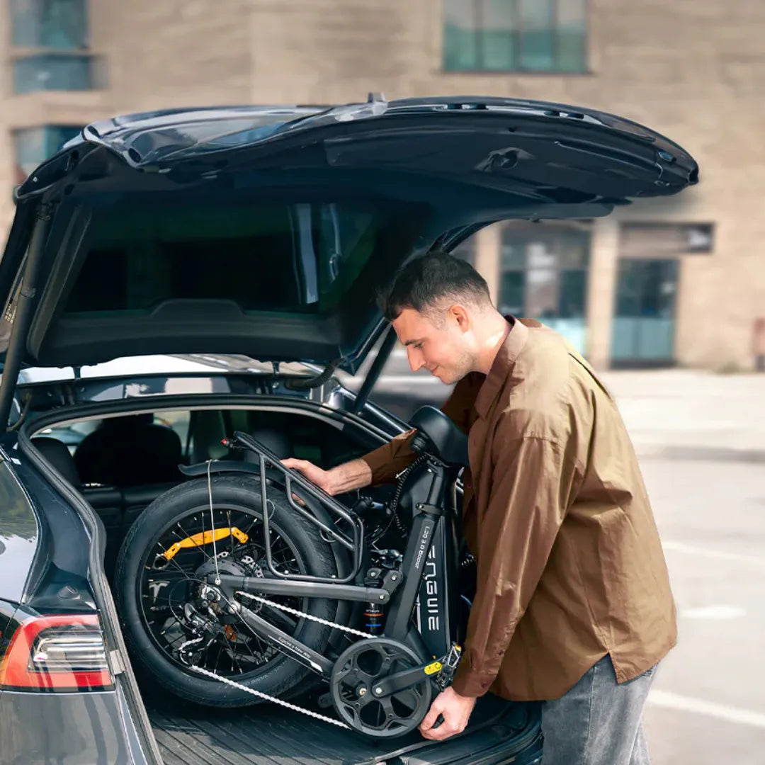 Muškarac sprema crni električni bicikl Engwe L20 3.0 Boost u prtljažnik automobila