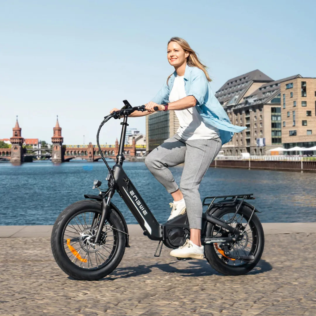 Žena vozi crni električni bicikl Engwe L20 3.0 Pro uz rijeku, bočni pogled