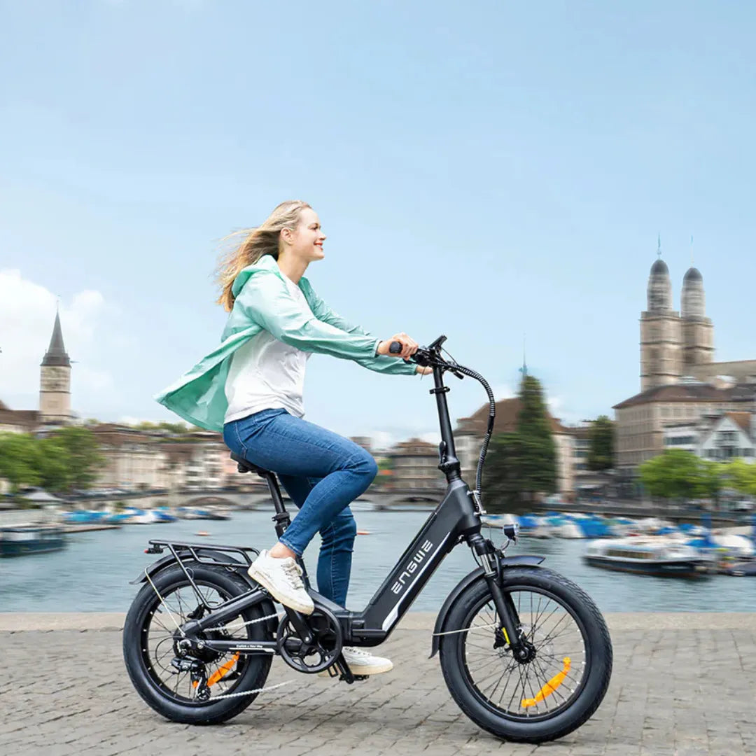 Žena vozi crni električni bicikl Engwe L20 3.0 Pro uz rijeku, bočni pogled