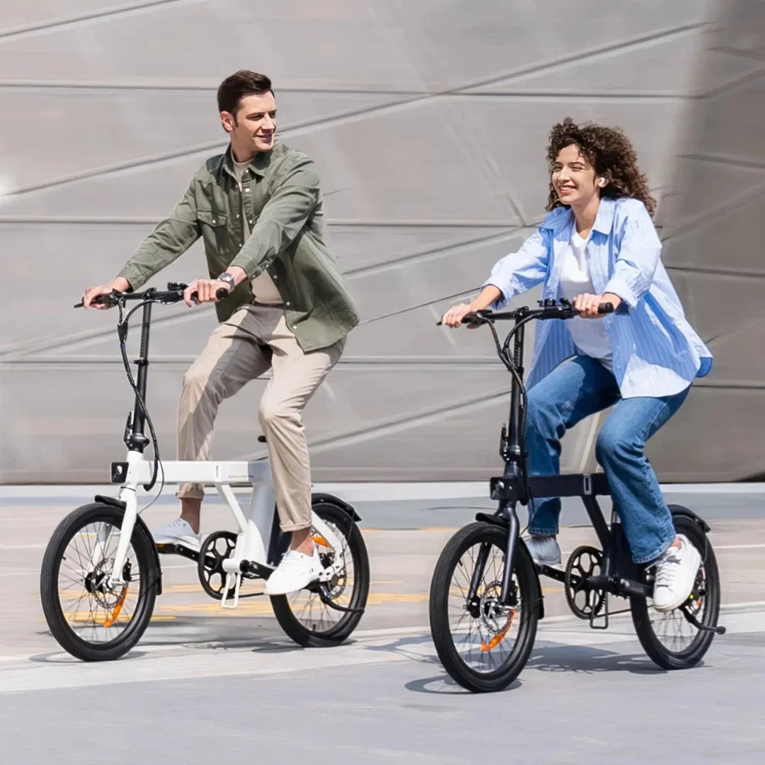 Muškarac i žena voze bijeli i crni sklopivi električni bicikl Engwe P20 na otvorenom
