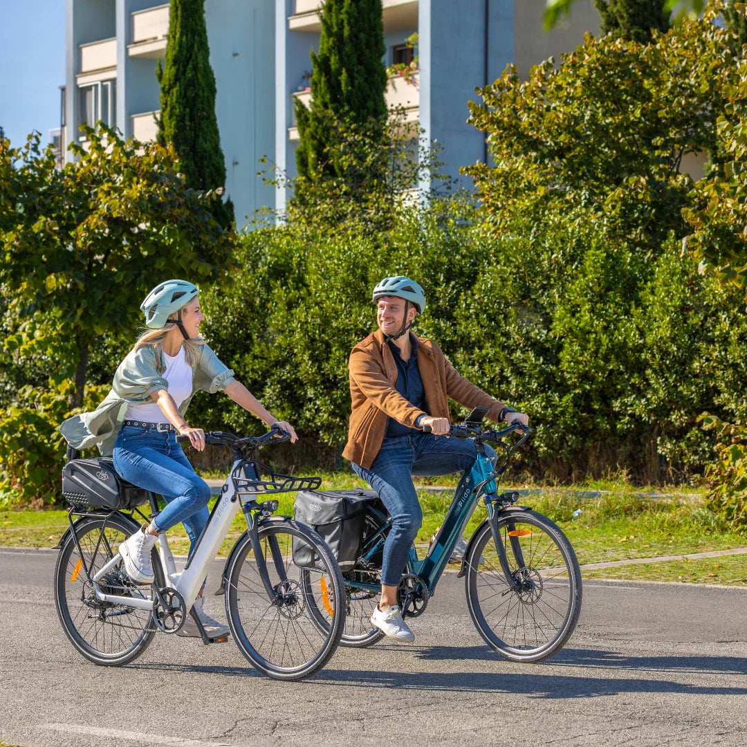 Par vozi bijeli i plavi električni bicikl Fiido C11 na cesti u prirodi