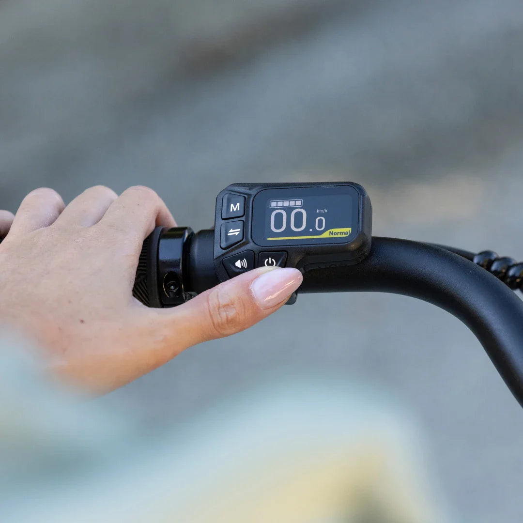 LCD zaslon s kontrolama na upravljaču električnog bicikla Fiido C11, krupni kadar ruku na ručki
