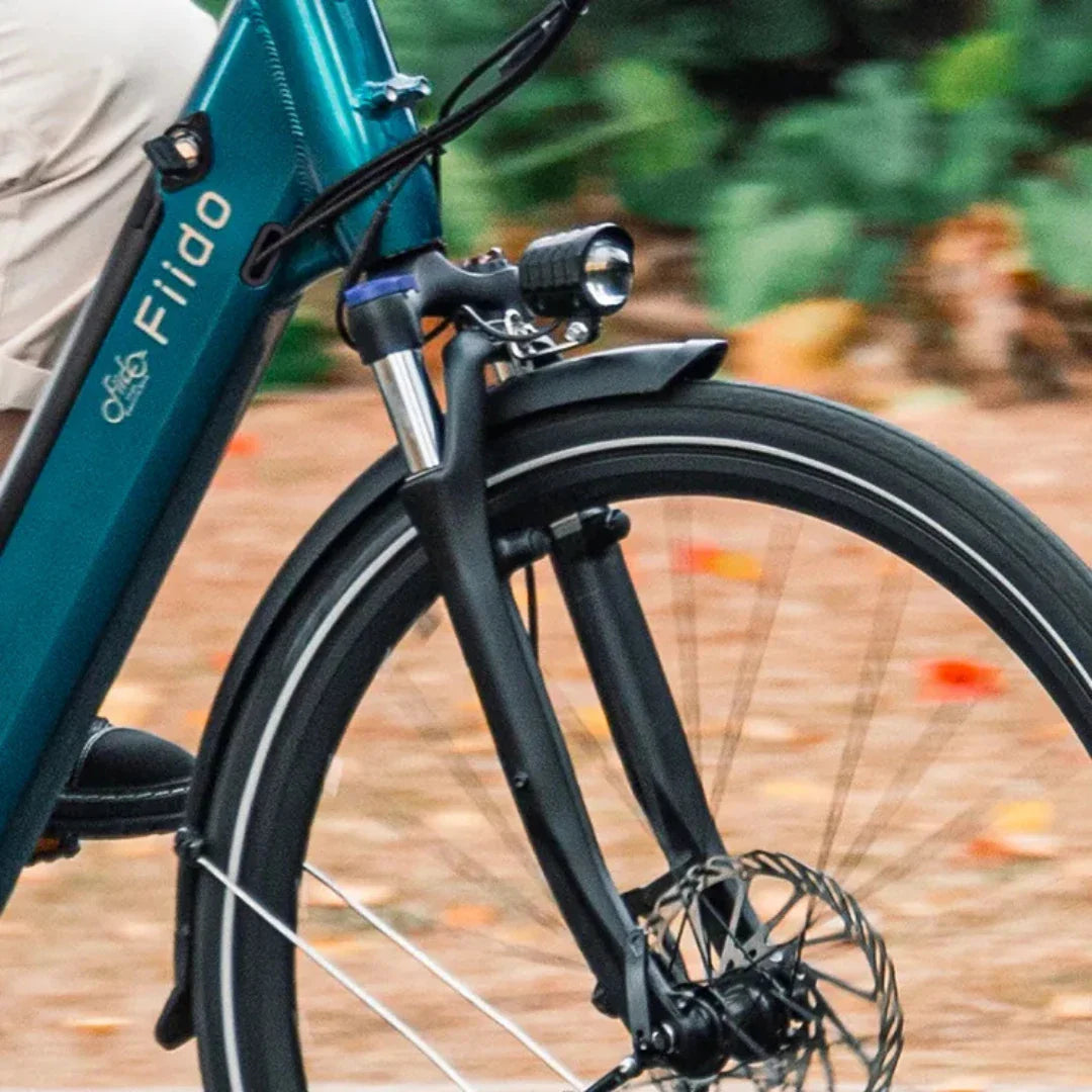 Prednji dio električnog bicikla Fiido C11 Pro s fokusom na vilicu, svjetlo i kotač tirkizne boje