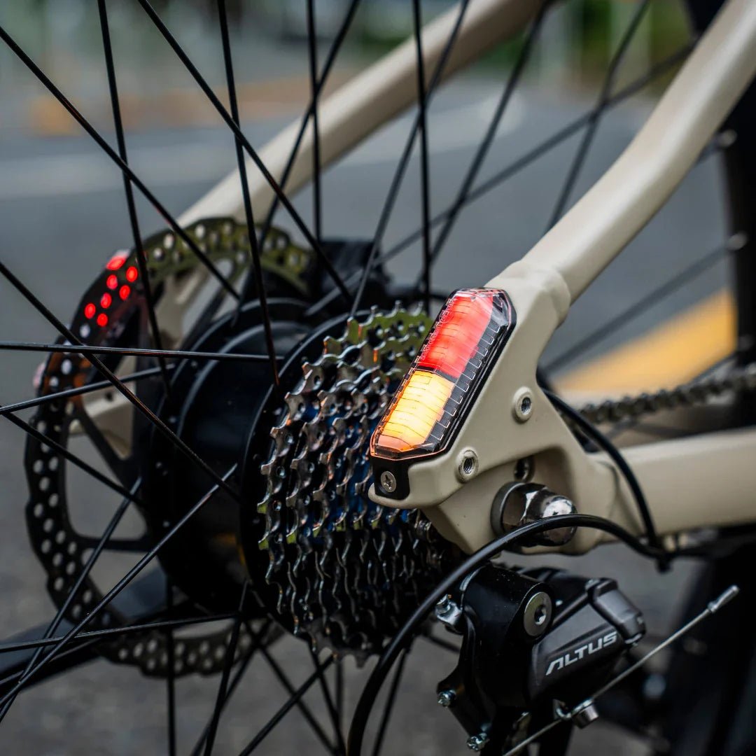 Detalj stražnjeg svjetla na bež električnom biciklu Fiido Nomad s kazetom i mjenjačem Shimano Altus