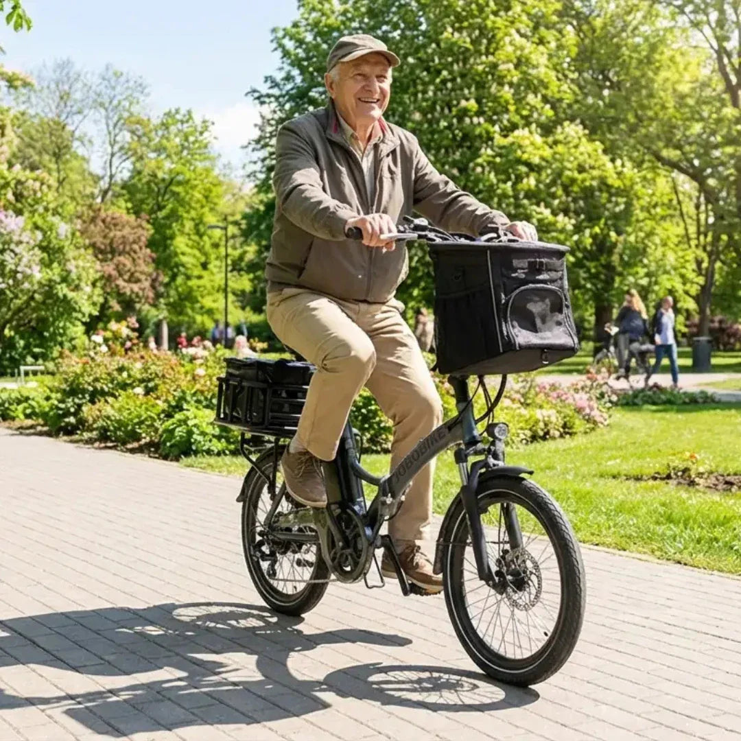 Stariji muškarac vozi sivi električni bicikl Jobobike Sam s košaricom u parku, pogled sa strane