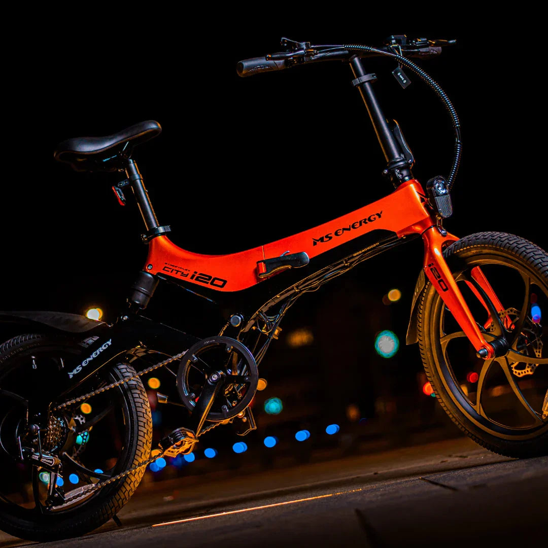 Narančasti električni bicikl MS Energy i20, profilni pogled na noćnoj pozadini