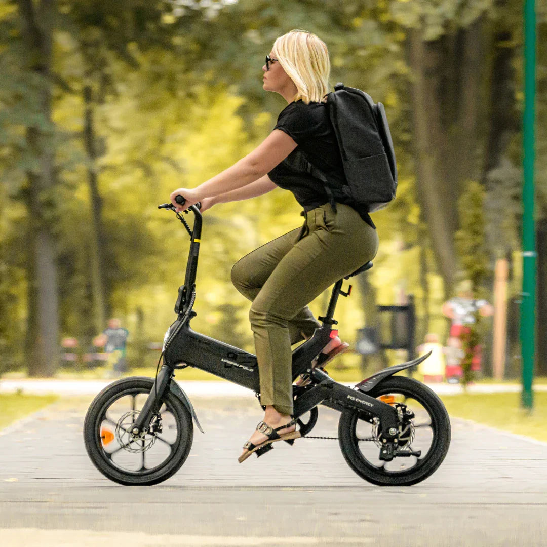 Žena vozi crni električni bicikl MS Energy UrbanFold i6 u parku, bočni pogled