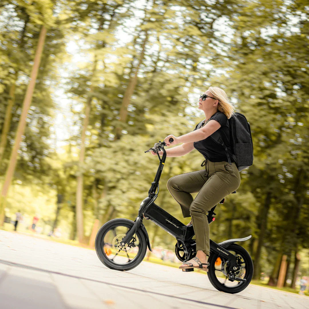 Žena vozi crni električni bicikl MS Energy UrbanFold i6 u parku, pogled sa strane