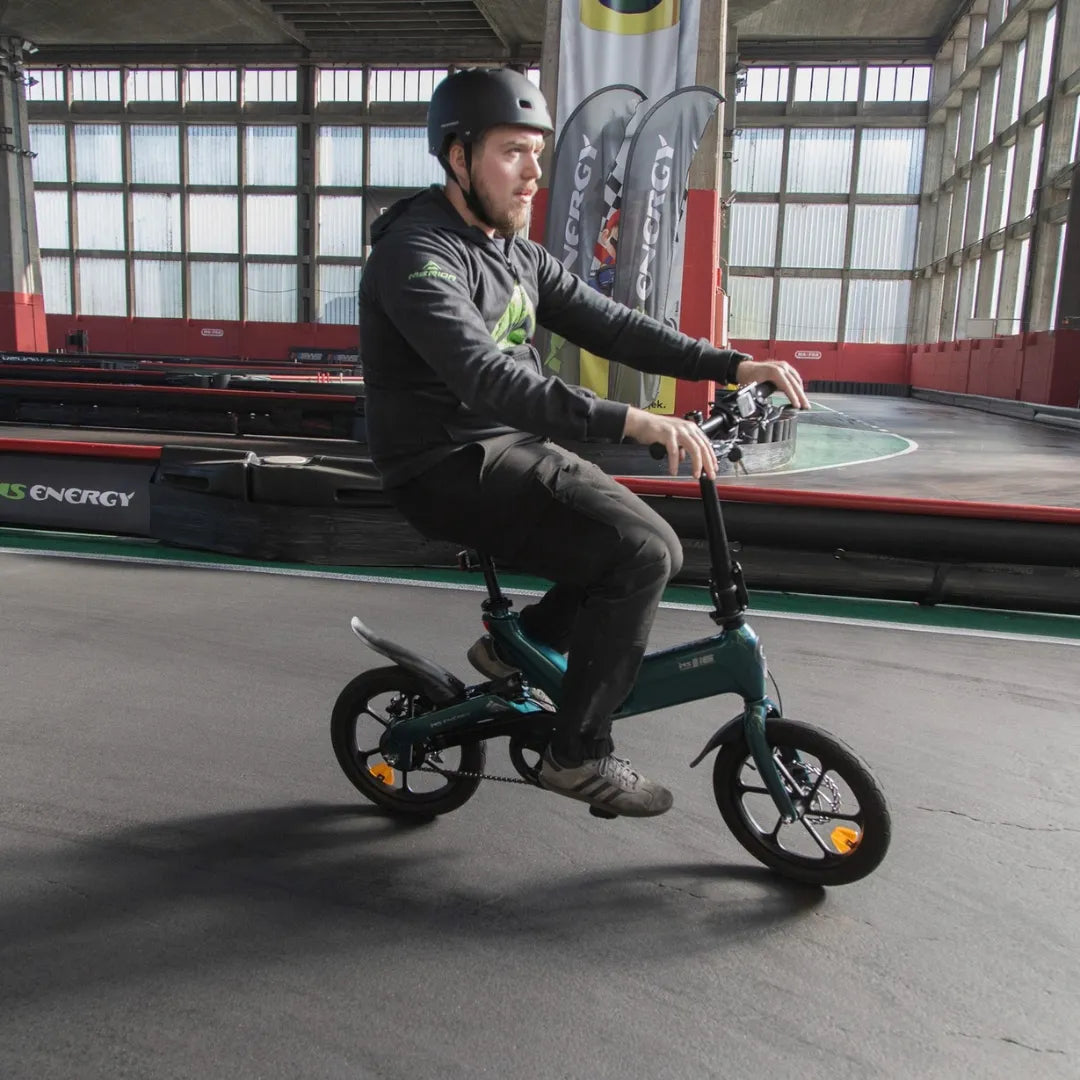 Muškarac s kacigom vozi zeleni električni bicikl MS Energy UrbanFold i6 na karting stazi