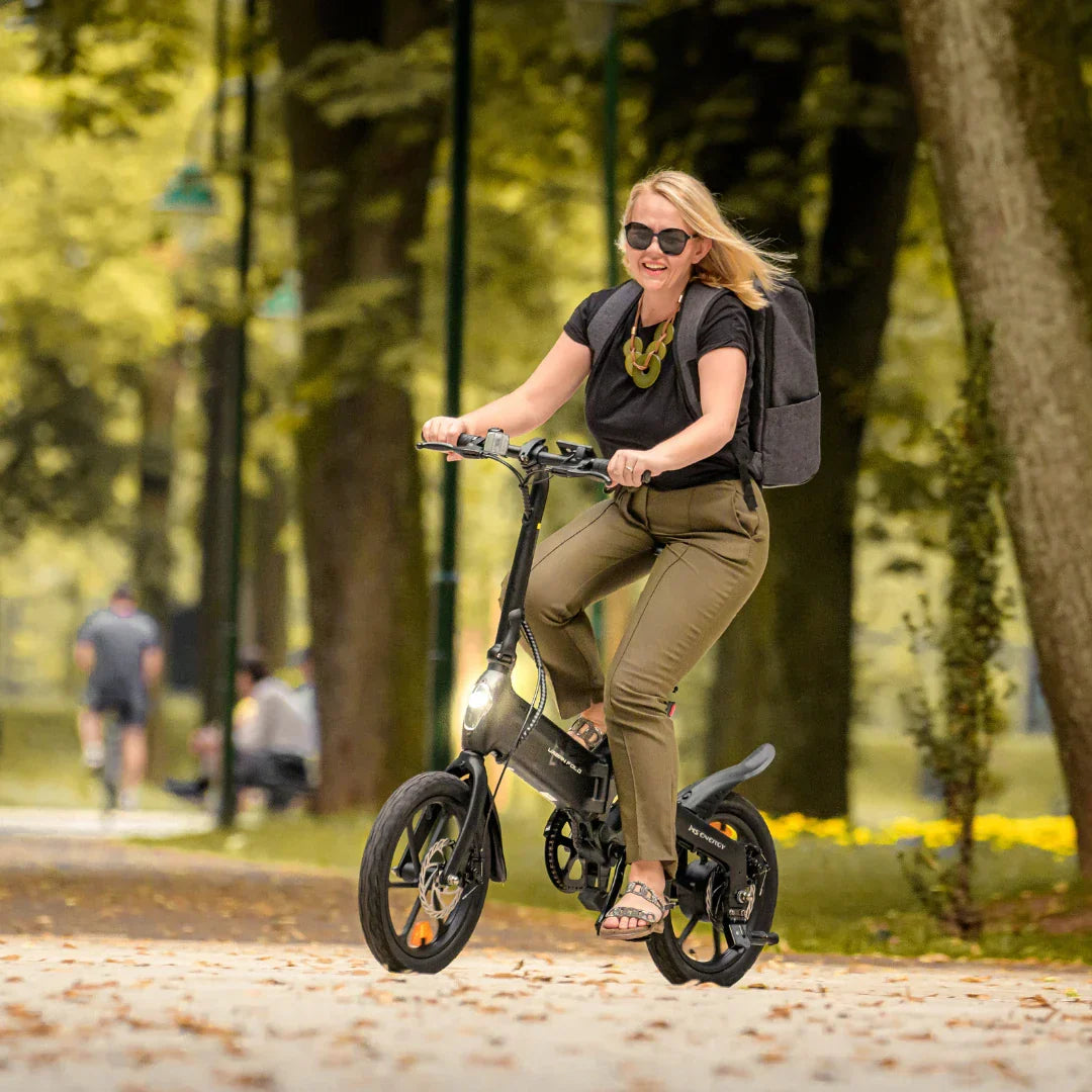 Žena vozi crni električni bicikl MS Energy Urban Fold i6 u parku, pogled sprijeda