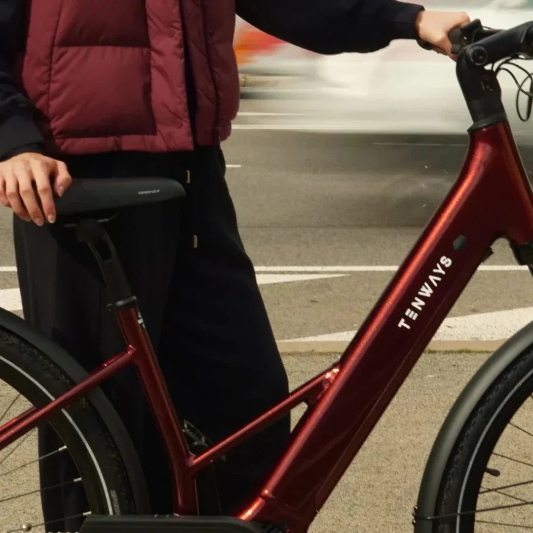 Krupni plan okvira crvenog električnog bicikla Tenways Ago Air u vožnji gradom
