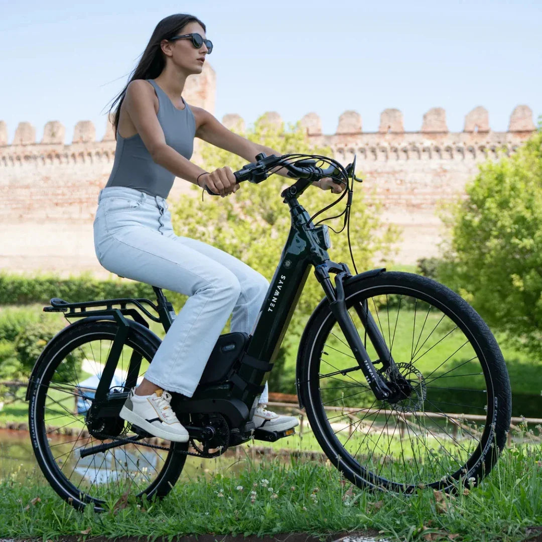 Žena vozi crni električni bicikl Tenways Ago T u prirodi, bočni pogled