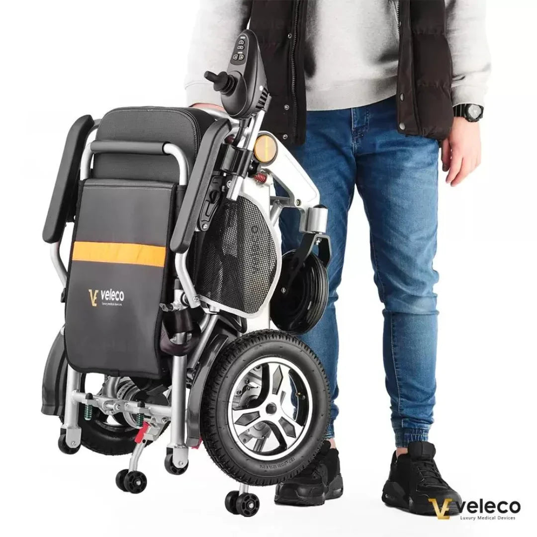 Sklopljena električna invalidska kolica Veleco Cosmo crno-sive boje u rukama osobe