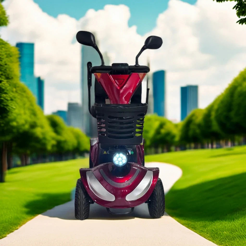Crveni električni skuter za starije osobe Eco Speed Senior pogled sprijeda s LED svjetlom i košarom u parku
