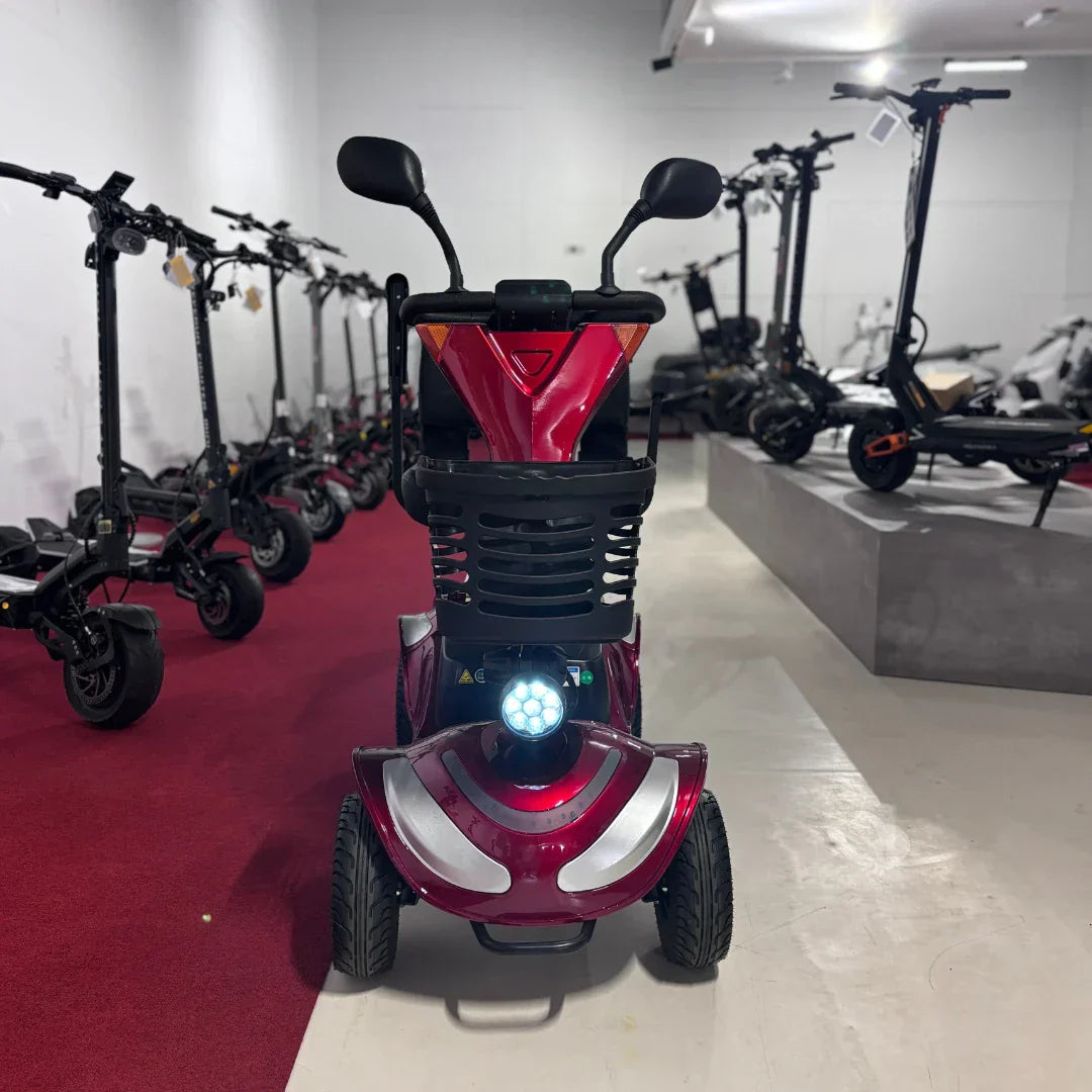 Crveni električni skuter za starije osobe Eco Speed Senior, pogled sprijeda s upaljenim prednjim svjetlom
