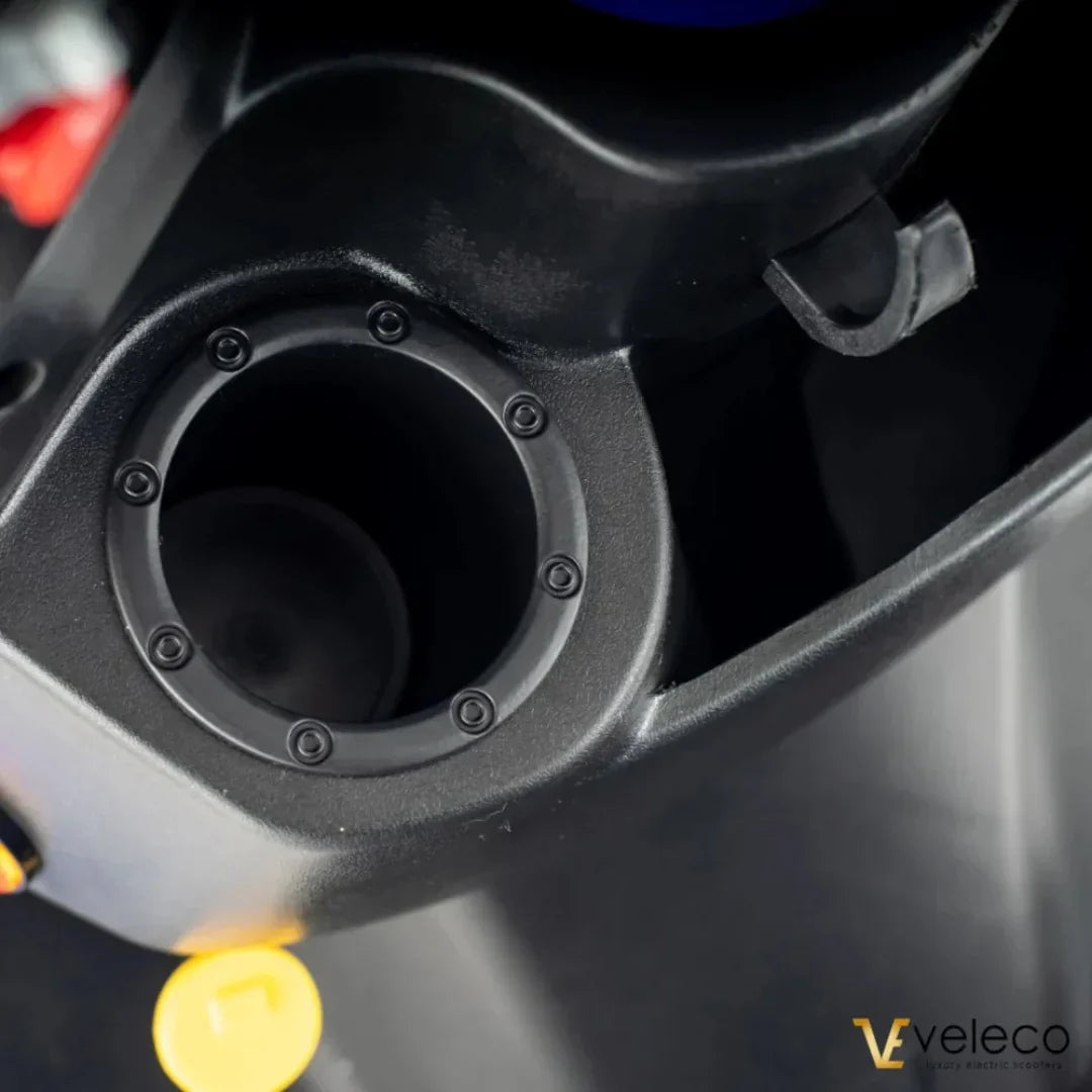 Detalj crnog držača za čašu na električnom skuteru Veleco Faster