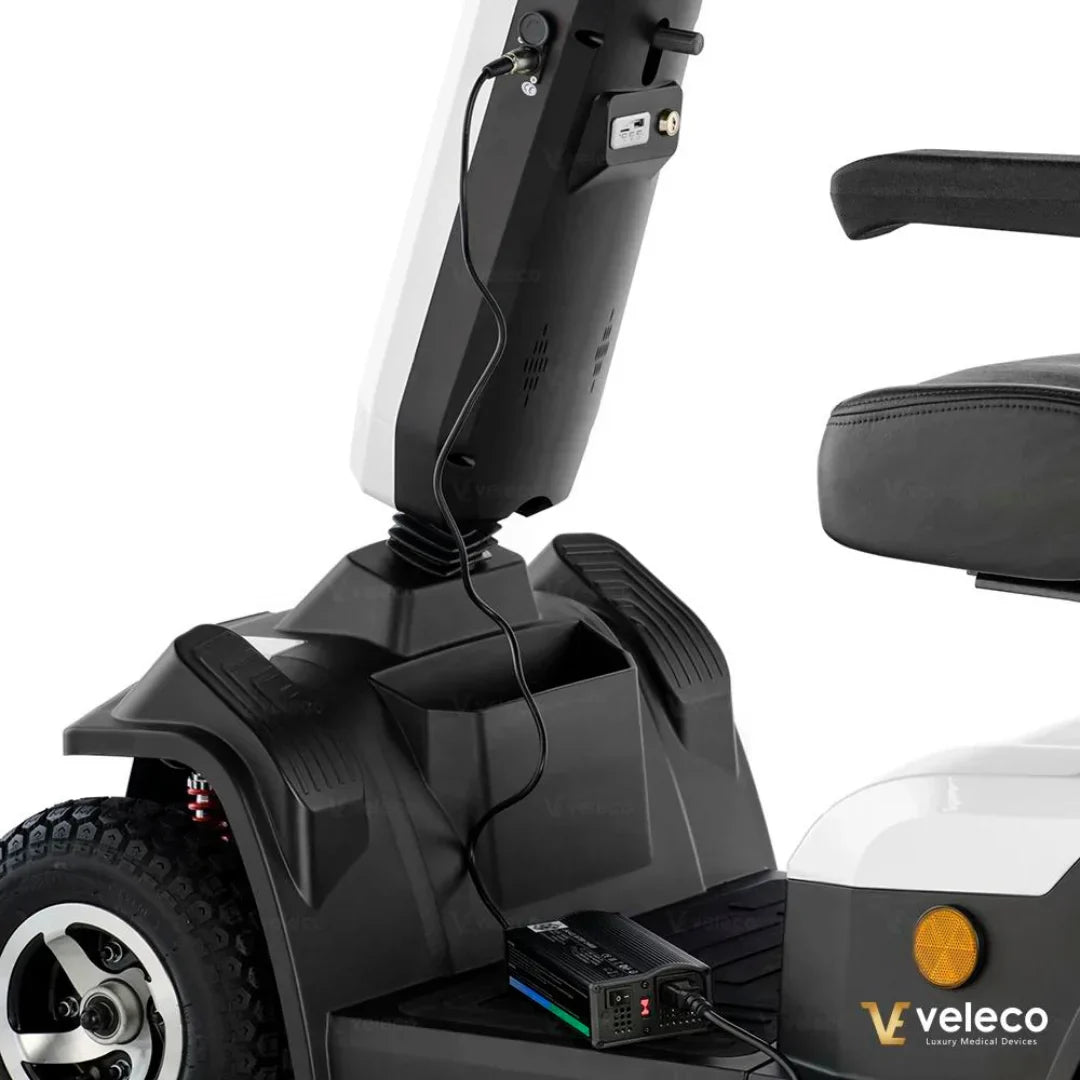 Detalj punjenja baterije električnog invalidskog skutera Veleco Sharpy, bijelo-crni dizajn