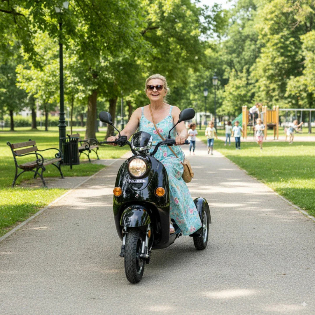 Starija gospođa vozi crni električni skuter Veleco ZT63 parkom, prednji pogled na vozilo