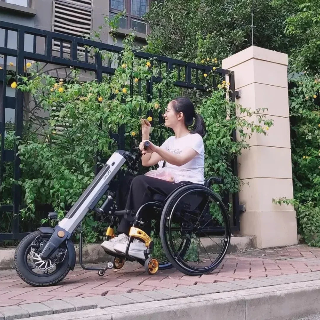 Žena koristi električni priključak Mijo MT03 postavljen na invalidska kolica, pogled sa strane