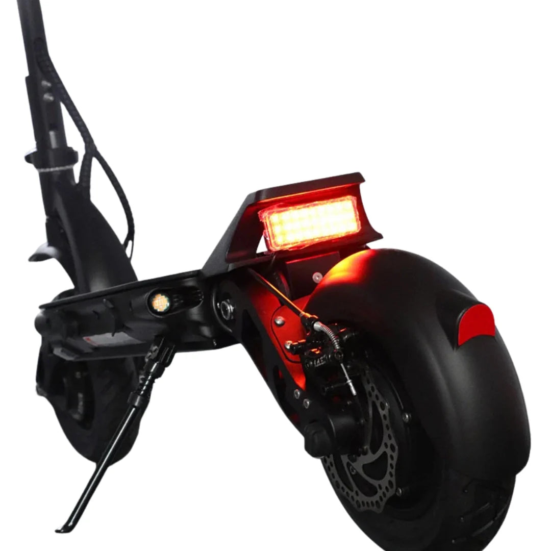 Stražnji dio crnog električnog romobila Dualtron Forever s upaljenim crvenim svjetlom i diskom