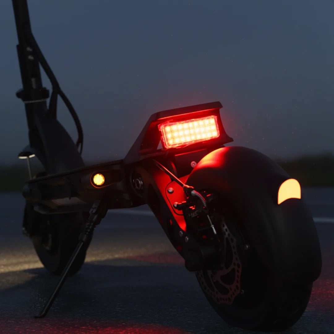 Stražnje svjetlo i detalj crnog električnog romobila Dualtron Forever noću