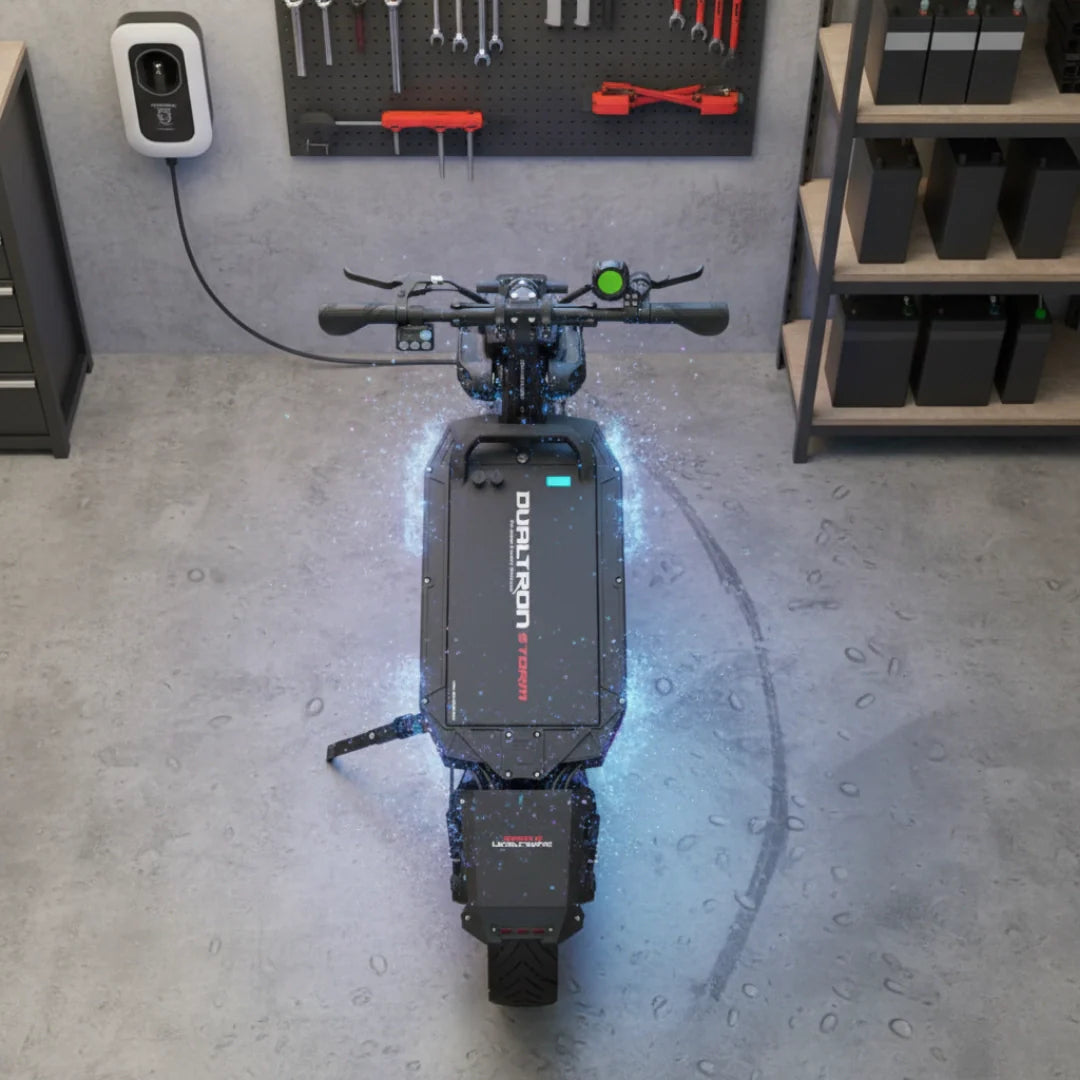 Električni romobil Dualtron Storm UP, pogled odozgo na crni romobil u garaži s plavim efektom