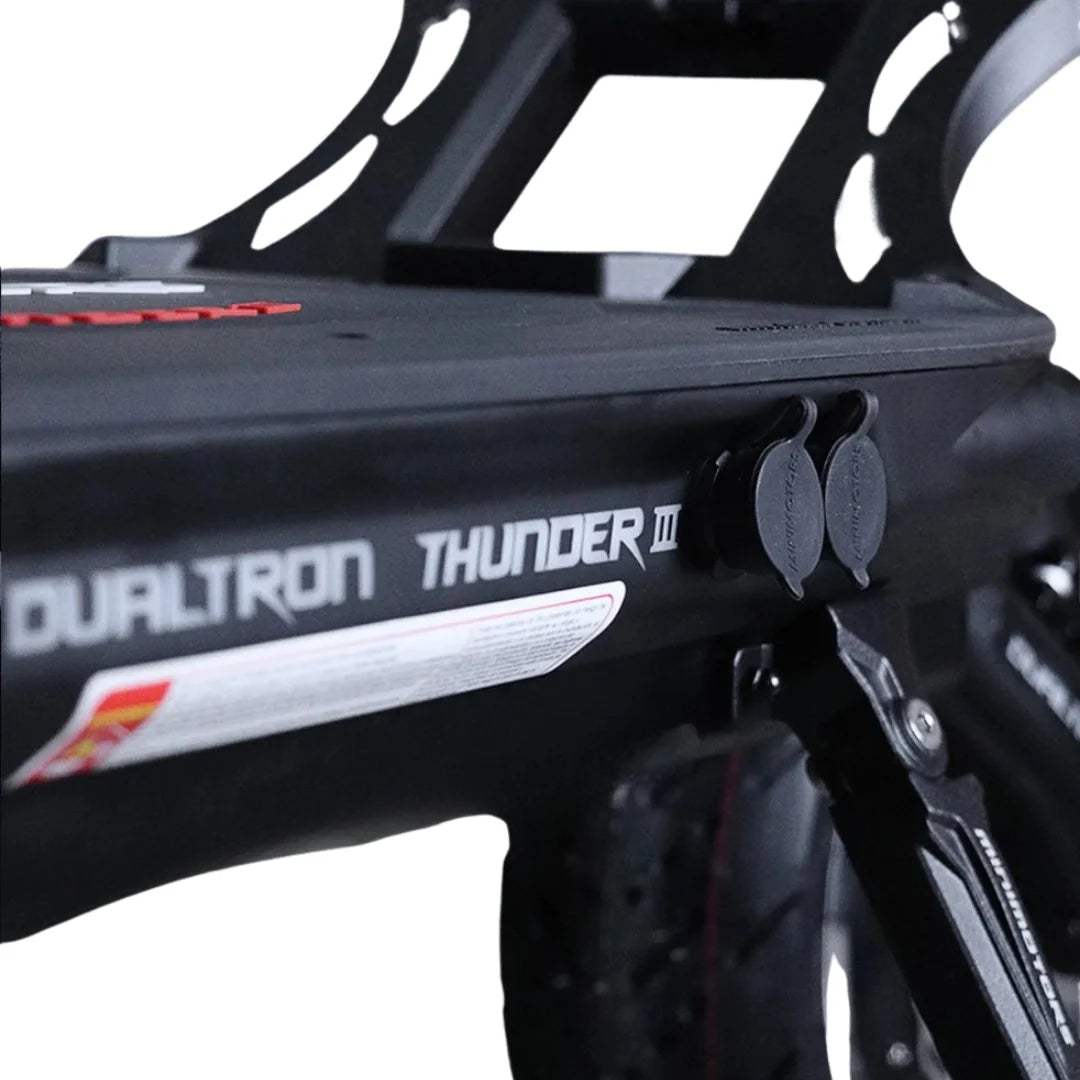 Detalj crnog električnog romobila Dualtron Thunder 3 s priključcima za punjenje na bazi