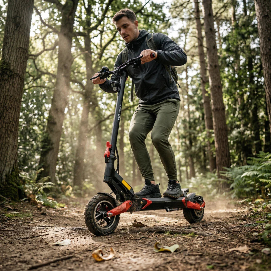 Muškarac vozi crno-crveni električni romobil Eco Speed 9 šumskom stazom, pogled sa strane