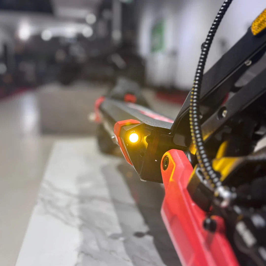 Krupni plan upaljenog žutog svjetla na crno-crvenom električnom romobilu Eco Speed 9X