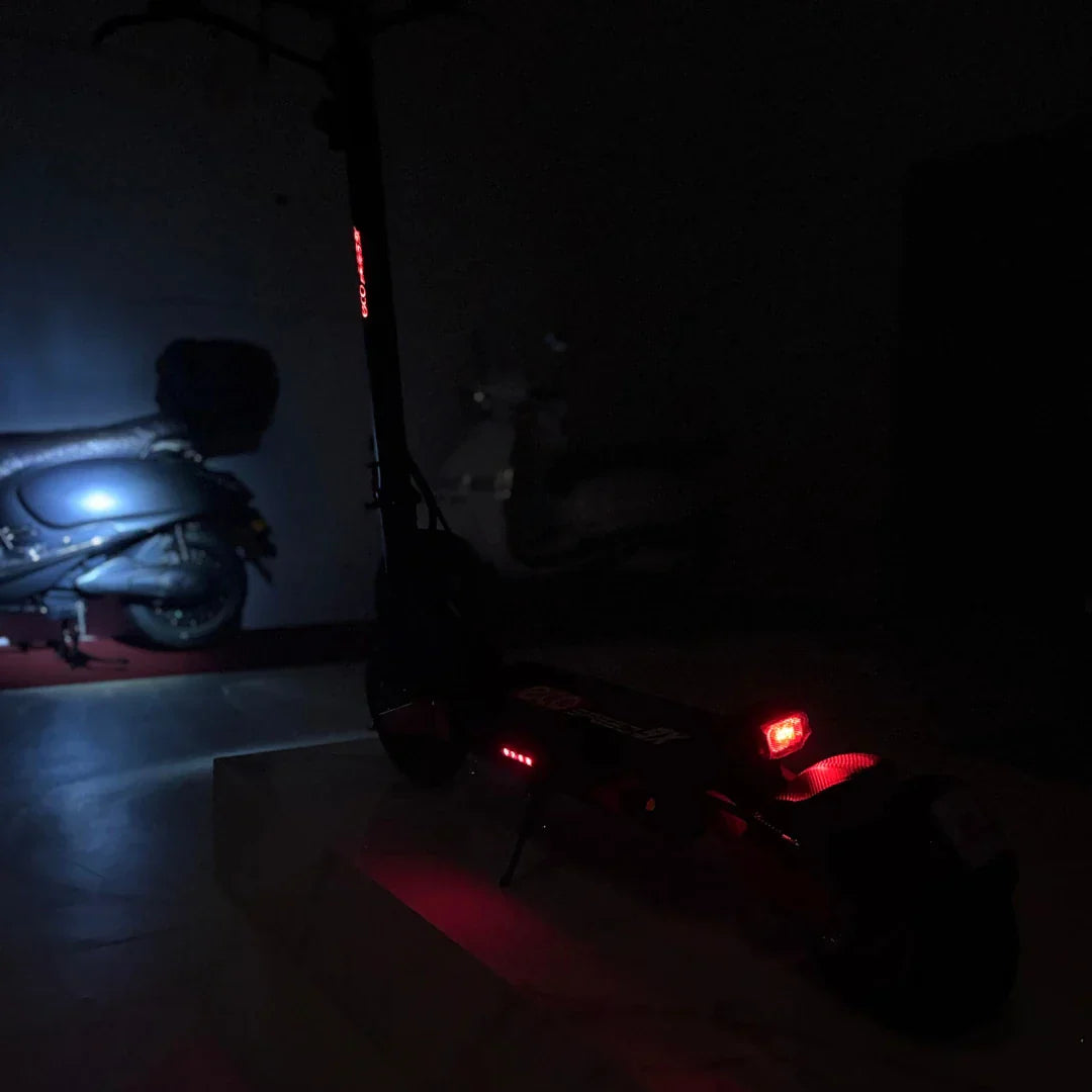 Električni romobil Eco Speed 9X sa upaljenim stražnjim crvenim svjetlom u mračnom prostoru