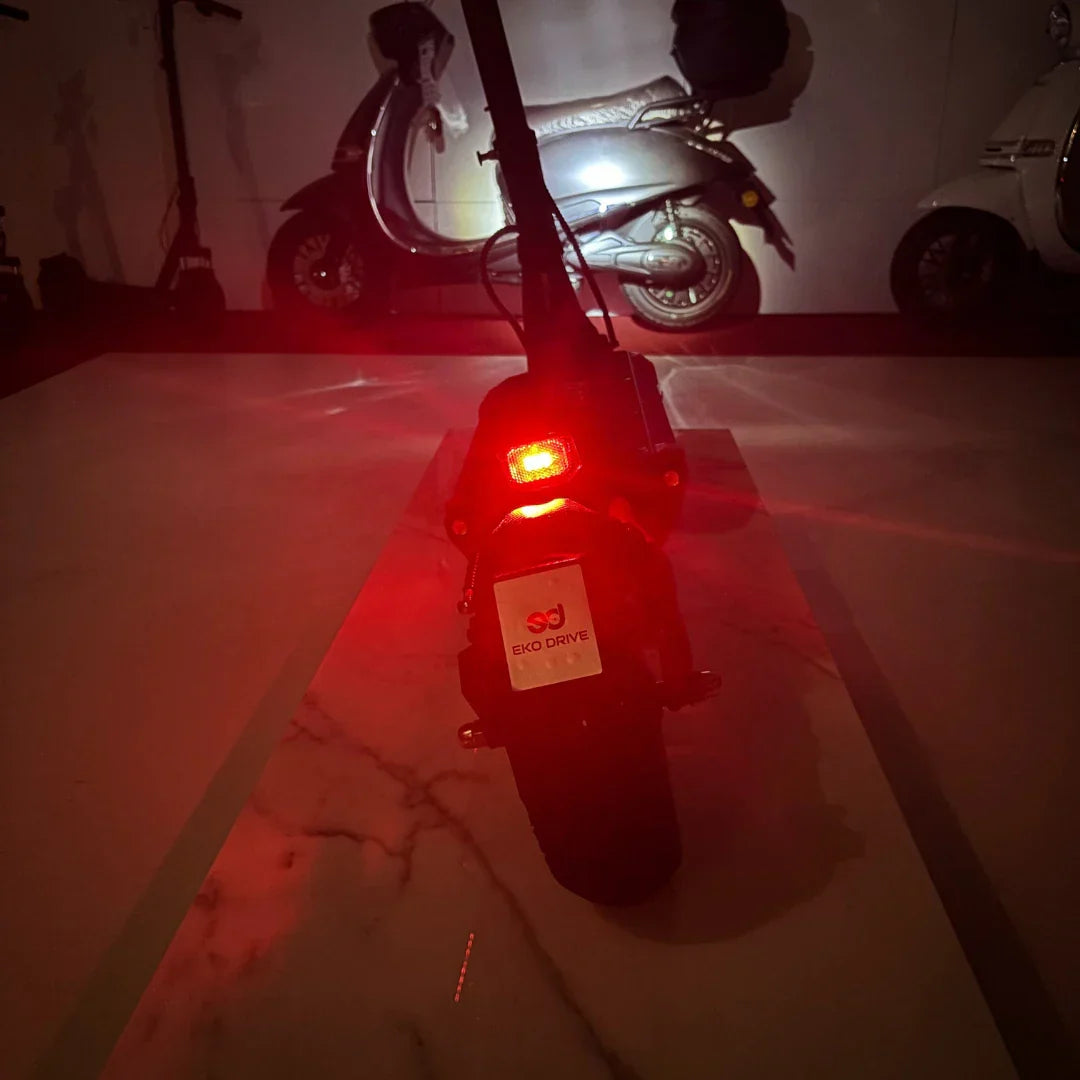 Stražnje crveno svjetlo električnog romobila Eco Speed 9x po noći uz logotip Eko Drive