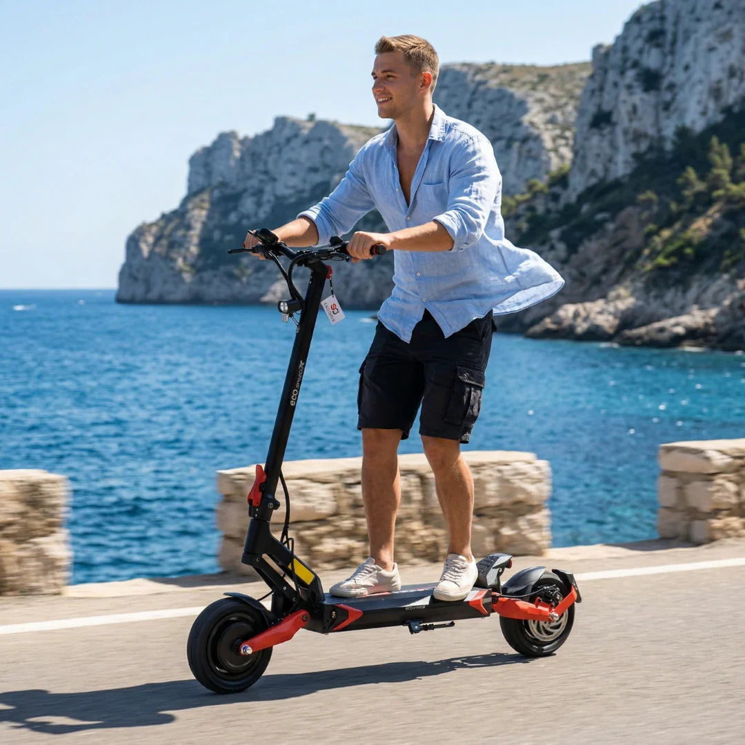 Muškarac vozi crno-crveni električni romobil Eco Speed 9X uz obalu mora