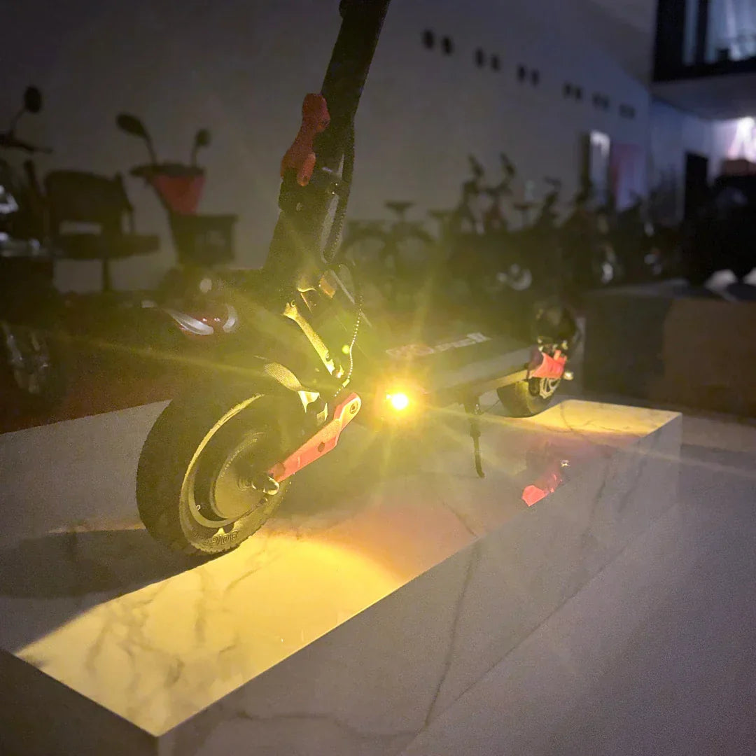 Električni romobil Eco Speed 9X sa upaljenim žutim svjetlima u mračnom salonu, pogled straga